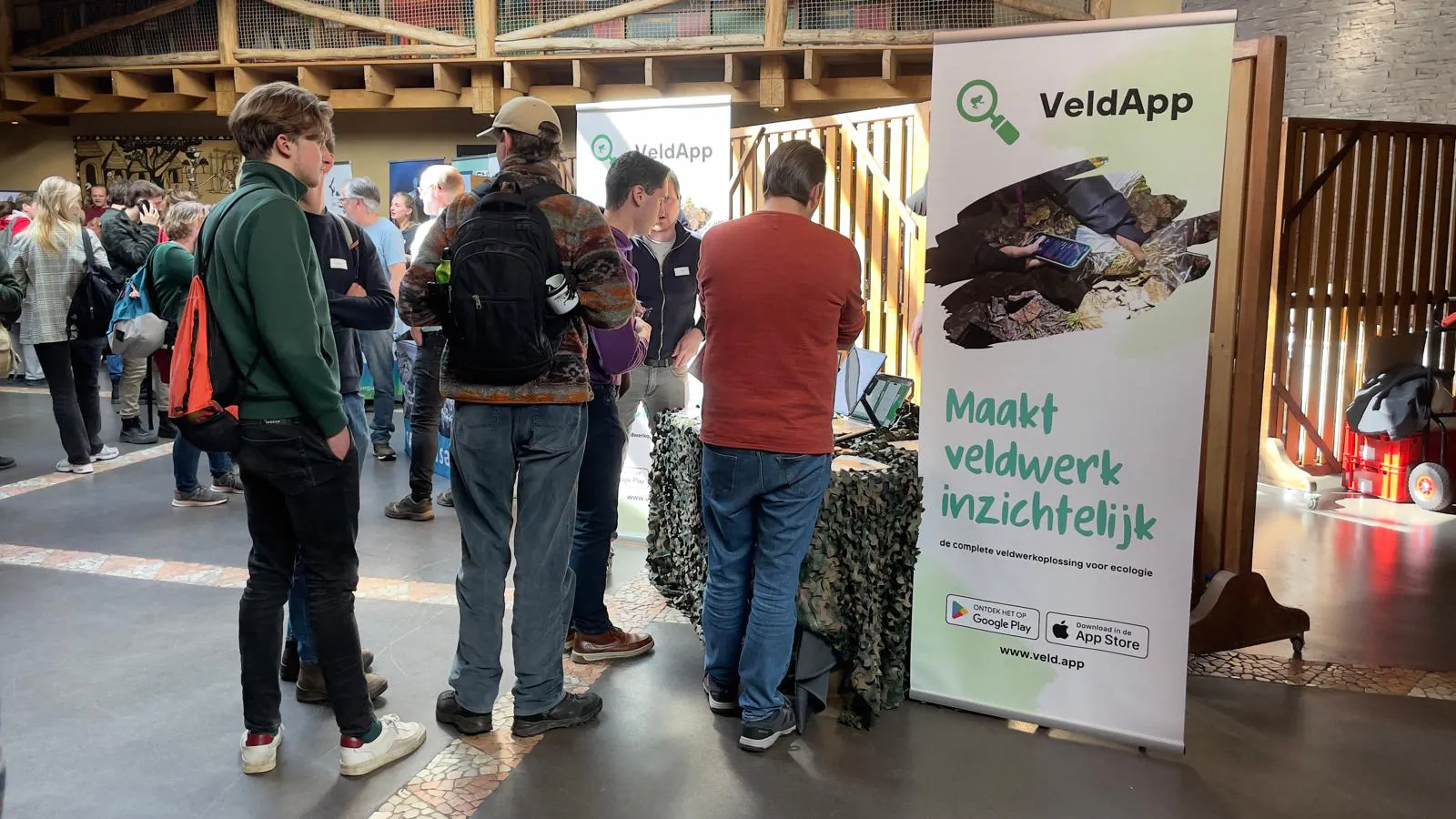 Bezoekers in gesprek bij de VeldApp-stand op Zoogdierendag 2025