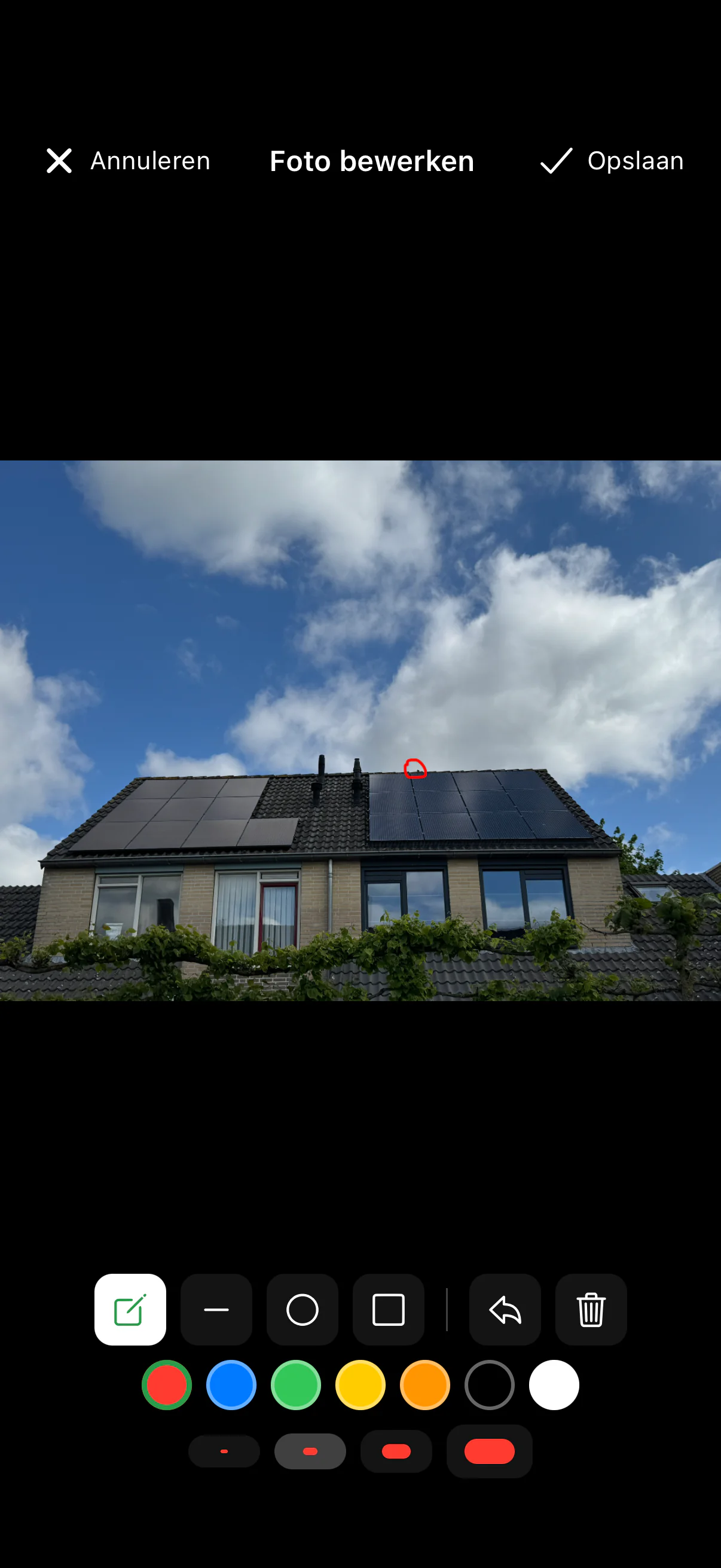 Het scherm Foto bewerken in de app: een dak met zonnepanelen, een rode cirkel om de invliegopening en onderaan de tekengereedschappen en kleuren